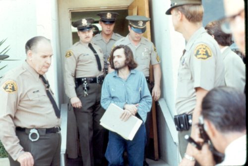 Charles Manson with police officers in 1970