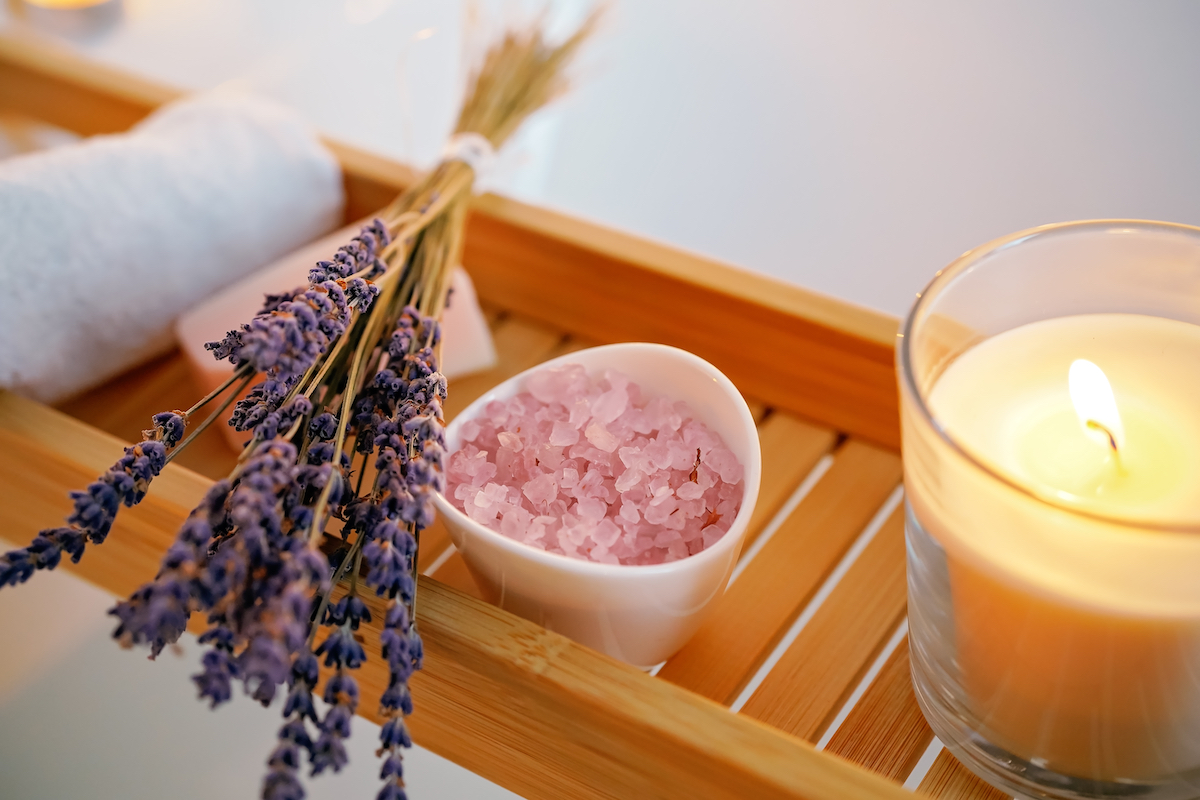 Lavender, salt, and a candle on a wood shelf for cleansing negative energy