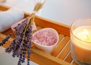 Lavender, salt, and a candle on a wood shelf for cleansing negative energy