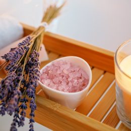 Lavender, salt, and a candle on a wood shelf for cleansing negative energy