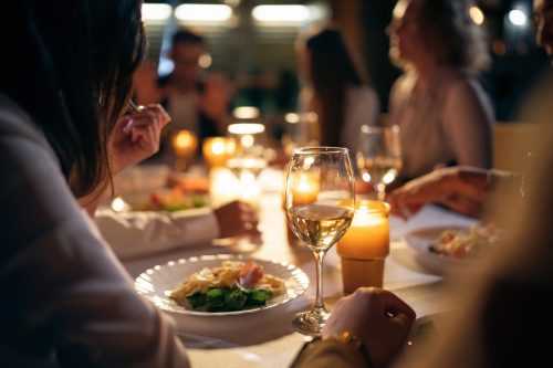 Một nhóm bạn nam và nữ đang ăn tối trên ban công của một nhà hàng