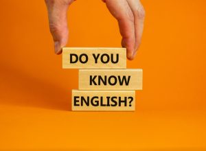 stack of blocks reading "do you know english" against an orange background