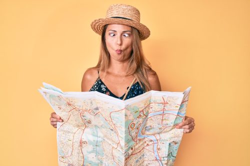 woman making a silly face while holding a map