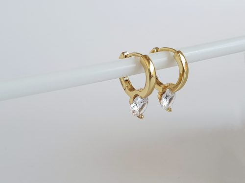 gold and crystal huggie earrings on white background