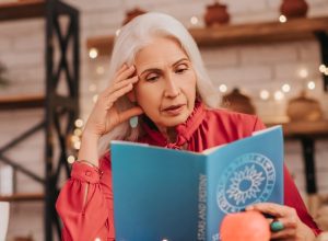 older woman reading astrology book
