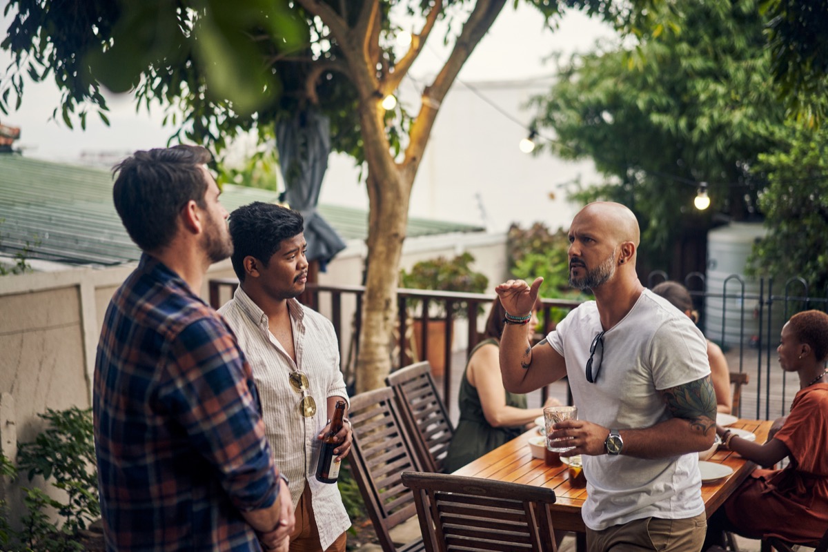 Shot of a group of young men having drinks at a dinner party outdoors