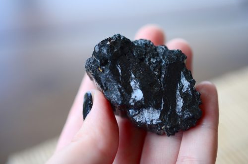 Close up of a Black Tourmaline crystal in someone's hand