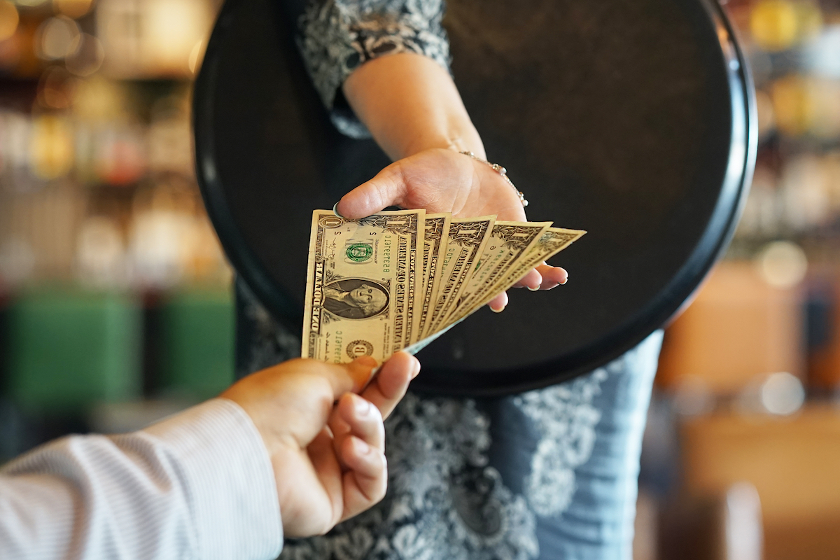Close up of a waitress accepting cash from a customer