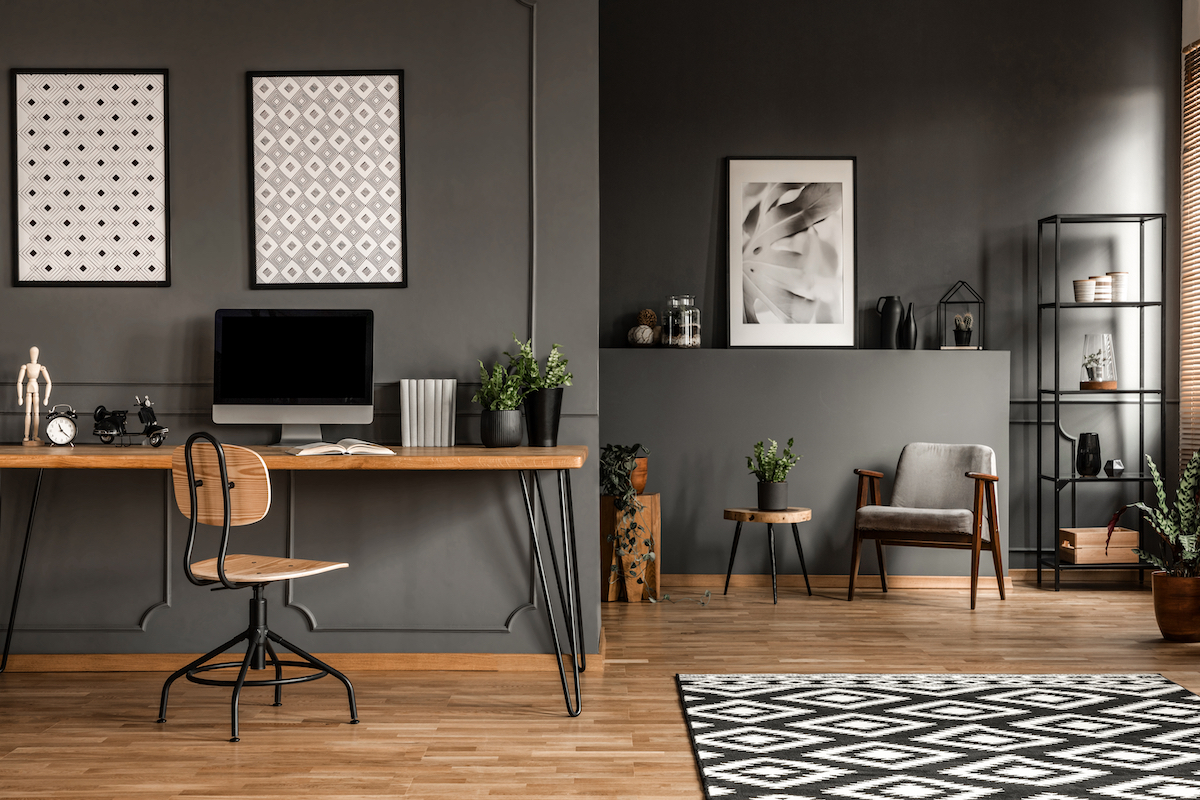 View of a modernist home office with dark gray walls and wood accents