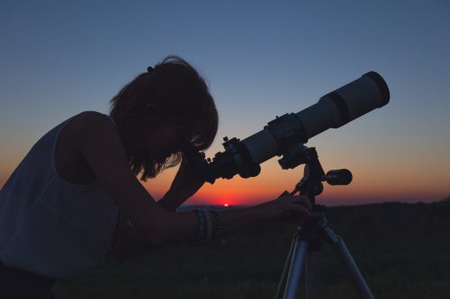 woman with telescope at night