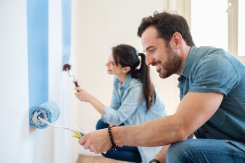 young couple painting house