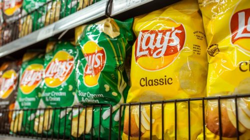 Lay's a popular brand of potato chips on display at an aisle in a supermarket.
