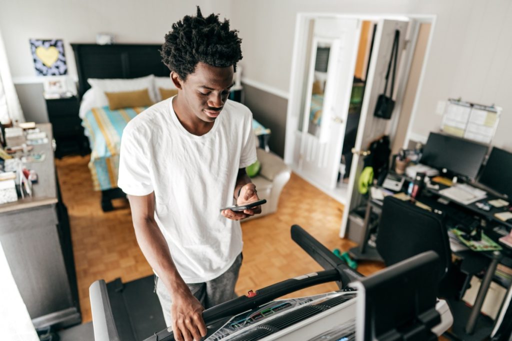 Young men using treadmill in his bedroom
