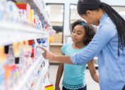 A woman and a young girl shop for OTC medicine in a pharmacy
