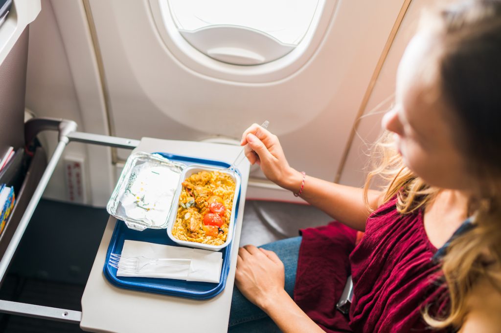 Airplane passenger eating food during a flight.