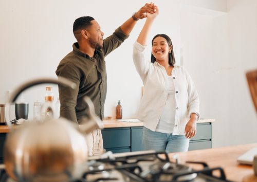 man twirling his wife in the kitchen