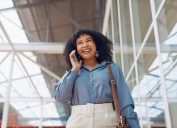 Cuộc gọi điện thoại, nụ cười hoặc hành trình của người phụ nữ da đen ở sân bay, tòa nhà văn phòng hoặc đường phố để liên lạc, mạng hoặc mạng 5g.  London, tín đồ công nghệ hoặc cô gái vui vẻ với điện thoại thông minh đi bộ, đi lại hoặc du lịch