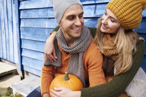 couple holding a pumpkin discussing fun fall facts
