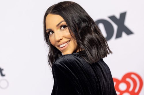 Close up of Scheana Shay wearing a black dress and looking over her shoulder smiling