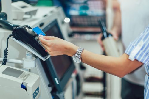 Couple with bank card buying food at grocery store or supermarket self-checkout