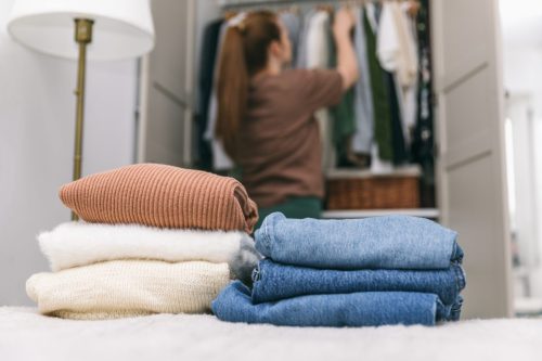 woman cleaning out and organizing closet