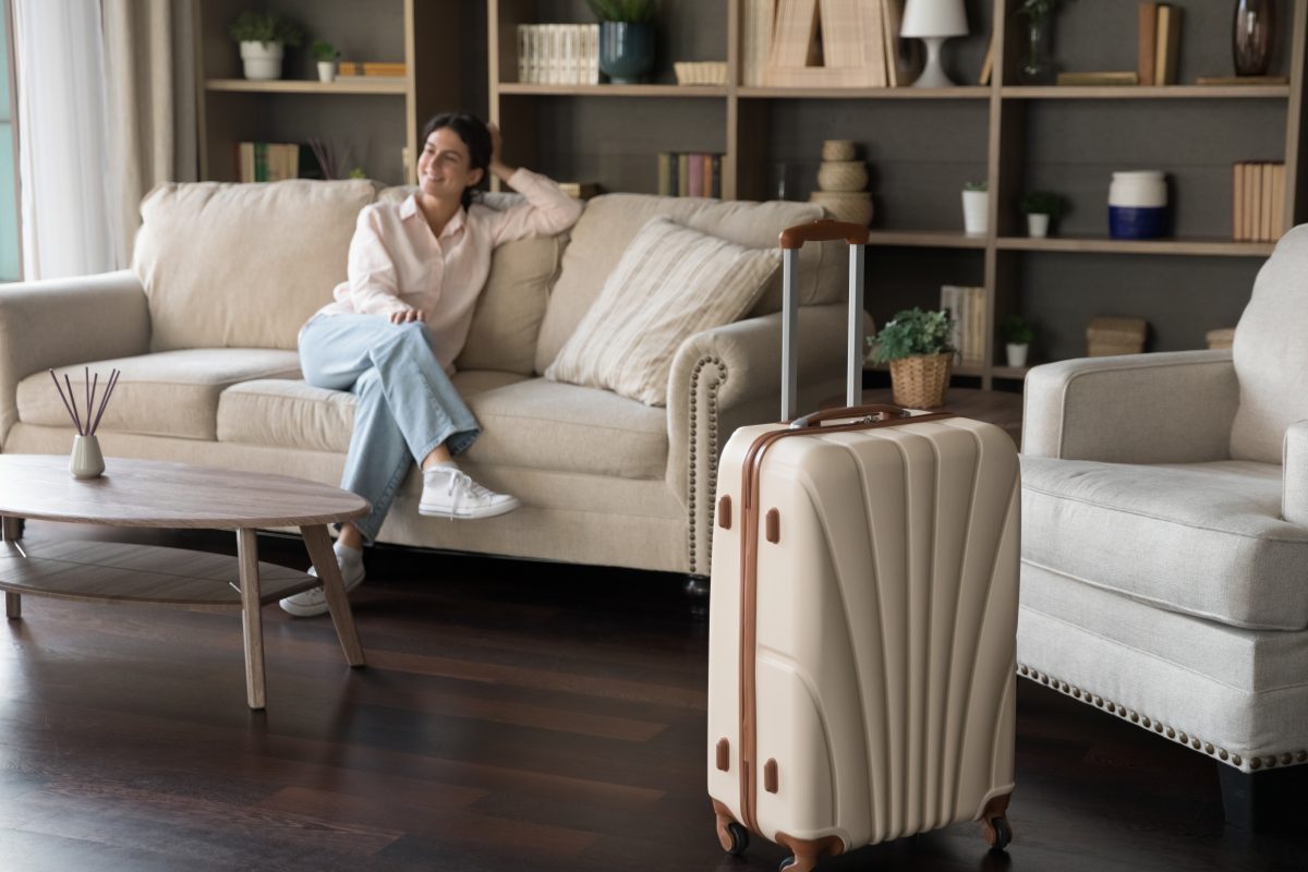 Woman guest on couch with suitcase