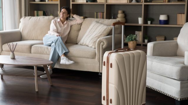 Woman guest on couch with suitcase