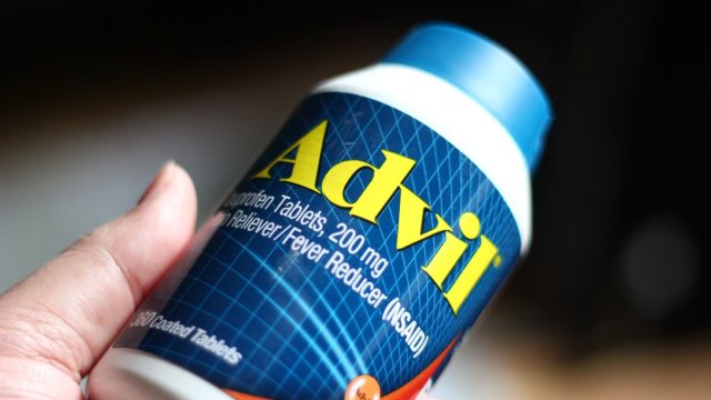 holding a bottle of advil