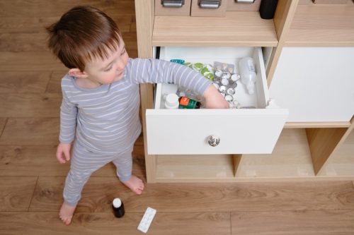 toddler reaching into medicine drawer