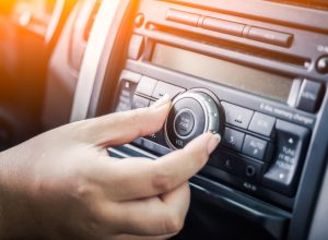 woman tuning radio in car