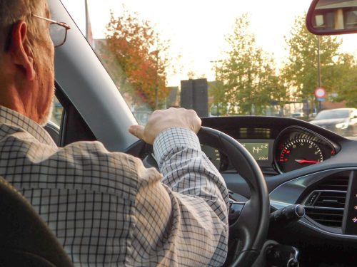 older man driving car