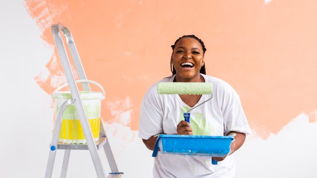 Smiling woman holding paint roller