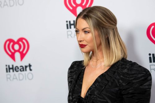 Close up side view of Stassi Schroeder posing in a black dress