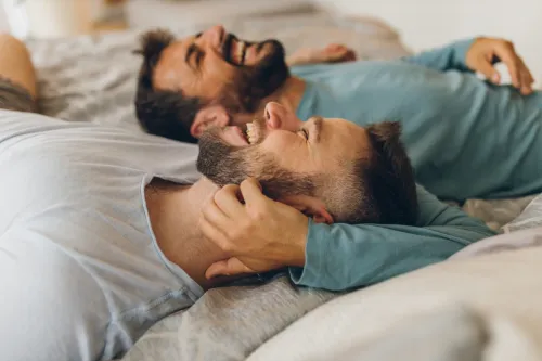 couple laying in bed exchanging good morning messages for him