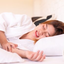Asian woman sleeping on the bed and grinding teeth