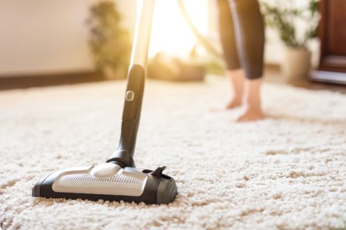 woman vacuuming a carpet