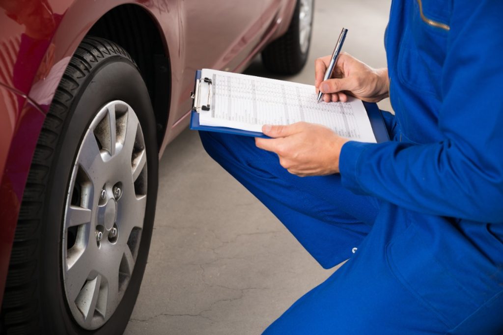 Car rental agent completing a vehicle inspection test.