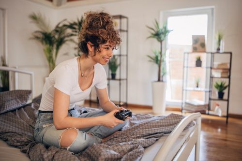 Woman playing video games in bedroom