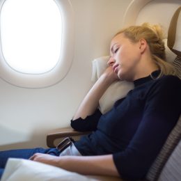 A woman sleeping on an airplane.