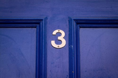 House number 3 on a blue wooden front door