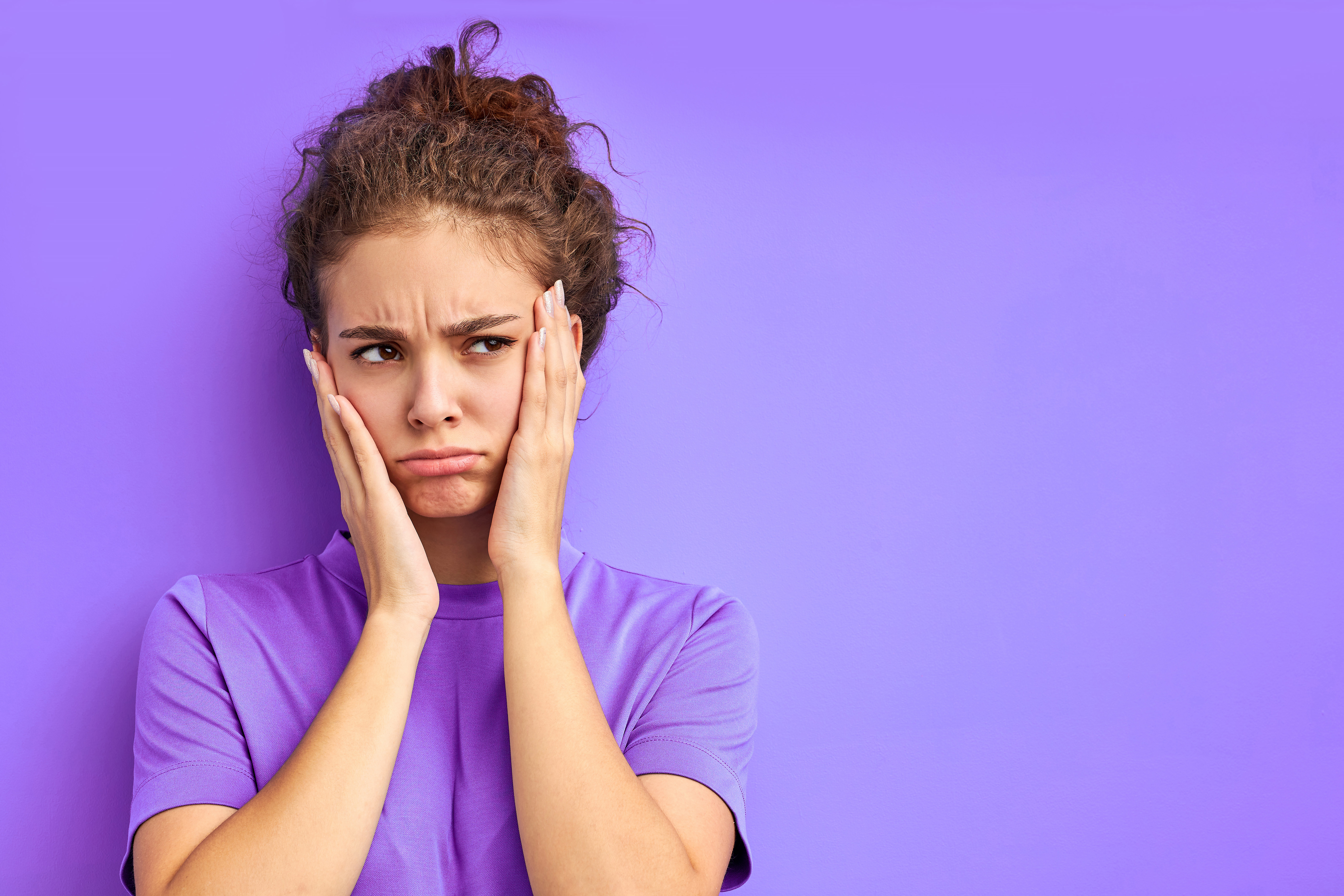 Unhappy woman wearing purple with purple background