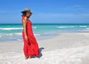 Người phụ nữ trưởng thành xinh đẹp mặc váy đỏ mùa hè trên bãi biển