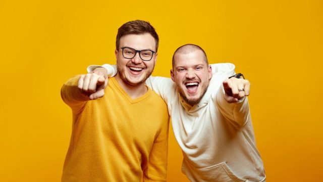 Two men pointing at camera and laughing