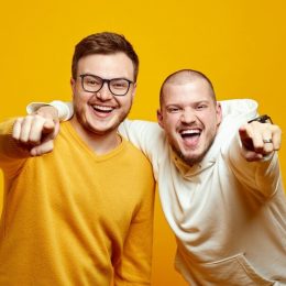 Two men pointing at camera and laughing