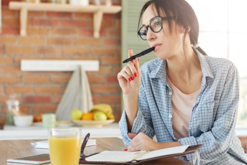 Woman Chewing on Pen While Thinking