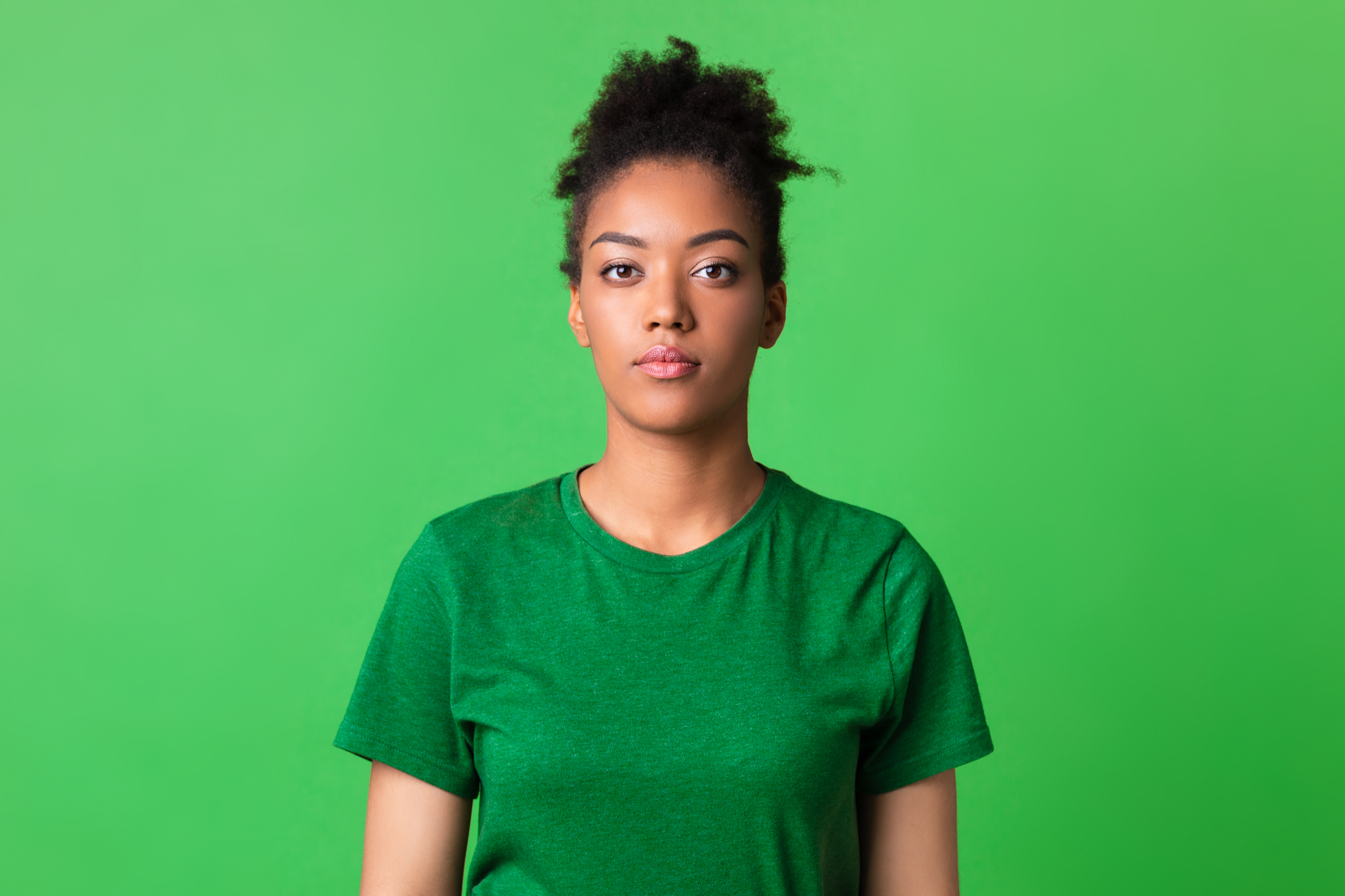 Unhappy woman wearing green with green background
