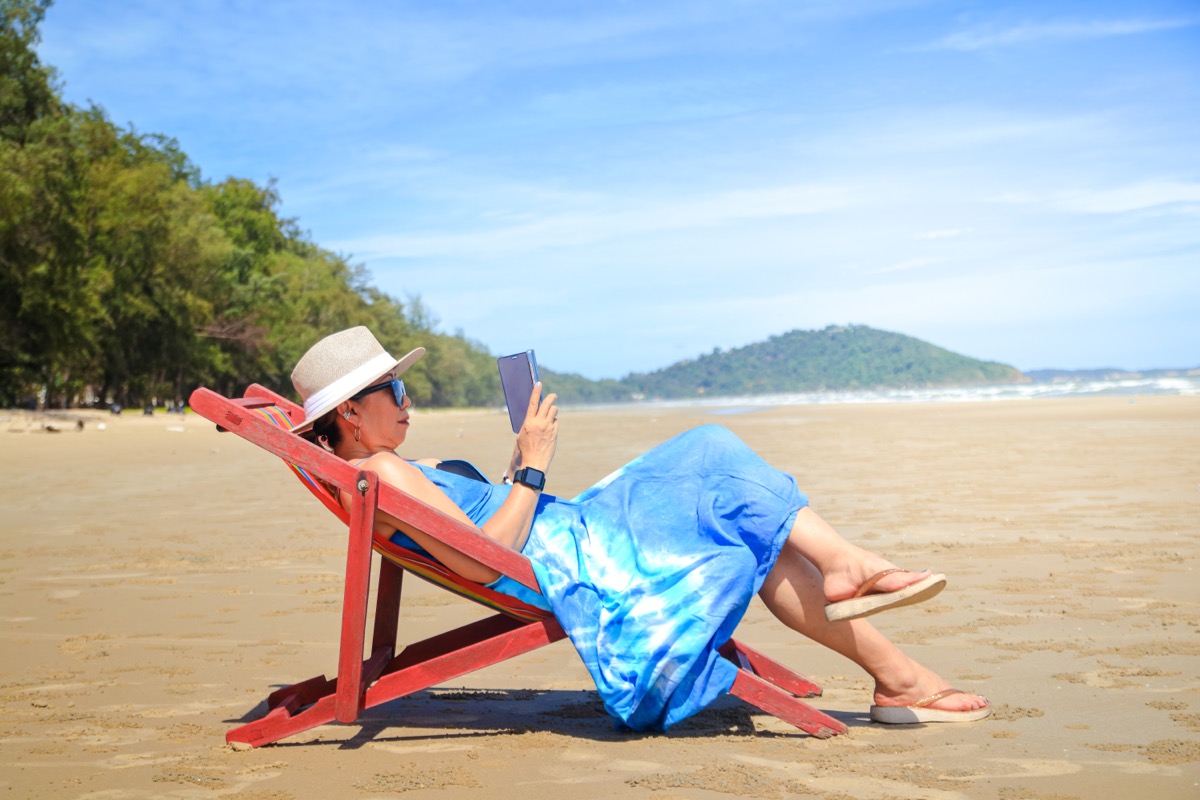 người phụ nữ sành điệu mặc áo dài màu xanh.  Ngồi dưới ánh mặt trời bên bờ biển trong khi ngắm nhìn phong cảnh tuyệt đẹp.  Du lịch biển Thái Lan bãi biển, Châu Á, Du lịch nghỉ hè