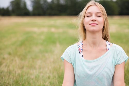 Young Woman With Eyes Closed in a Field