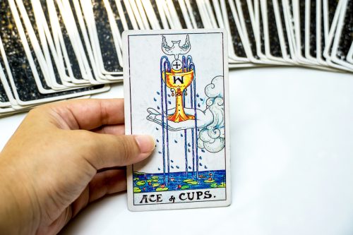 Ace of Cups tarot card with multiple cards behind