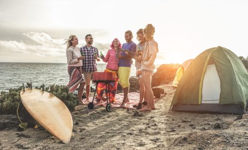 Những người bạn vui vẻ uống bia tại một buổi cắm trại BBQ bên bờ biển - Những người lướt sóng vui vẻ và cười đùa cùng nhau - Trọng tâm chính là đúng người - Khái niệm du lịch, kỳ nghỉ và tình bạn